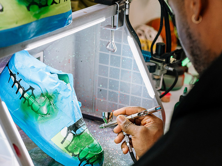 Close up of man creating custom sneaker art with an airbrush