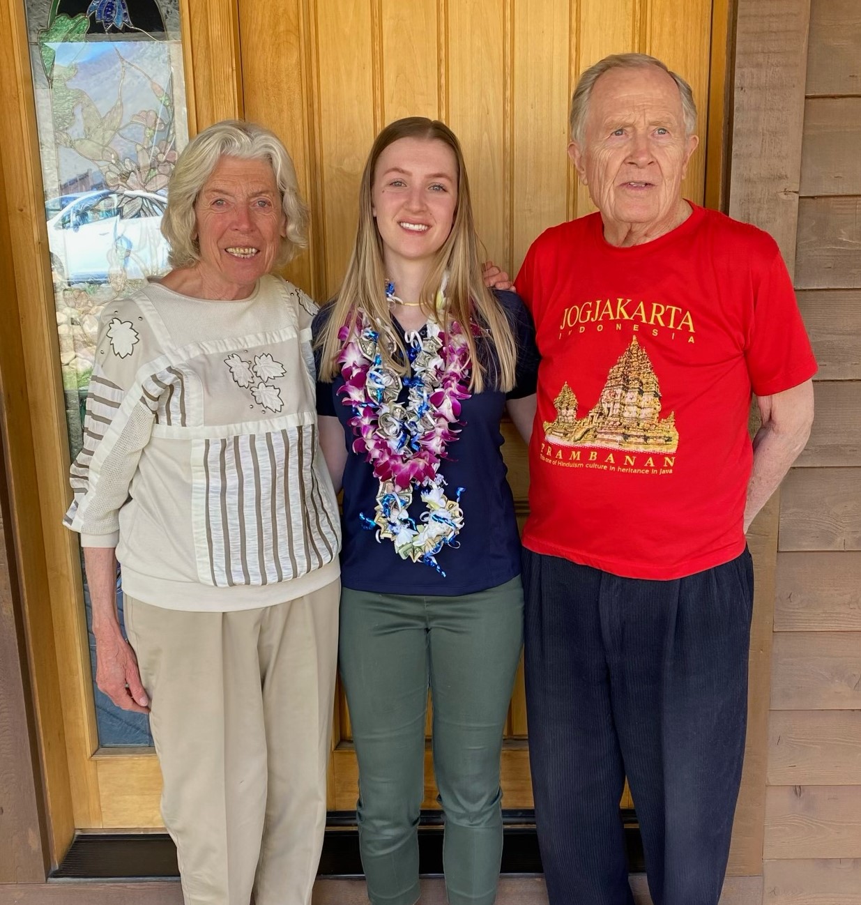 Grandparents and granddaughter in front of a door