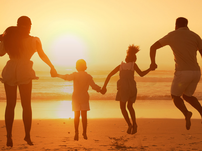 family jumping on the beach